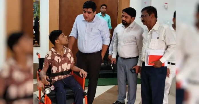 कलेक्टर कुणाल दुदावत दिव्यांग छात्र को वील चेयर प्रदान कर बात करते हुए